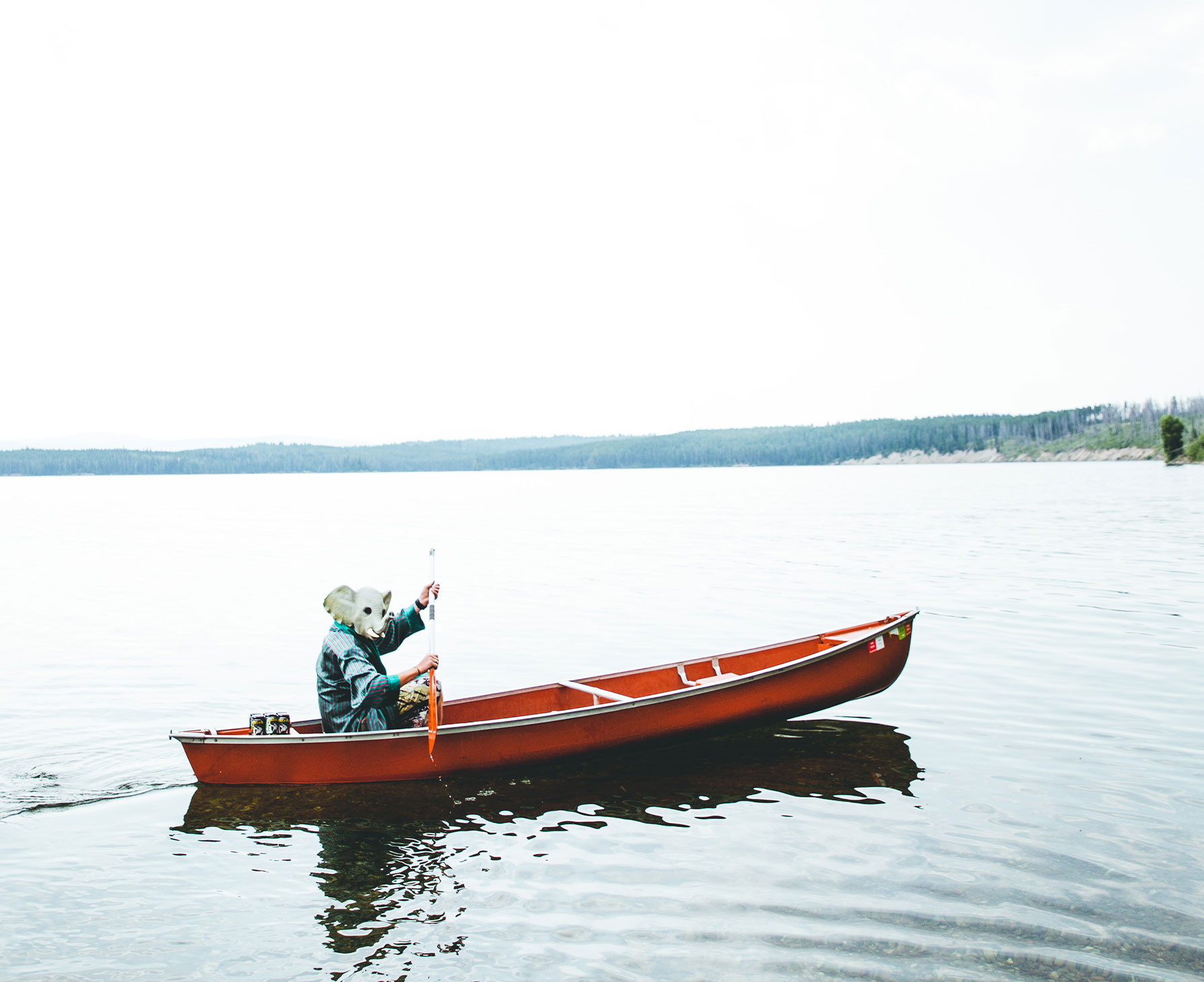 Person with elephant mask in a boat.